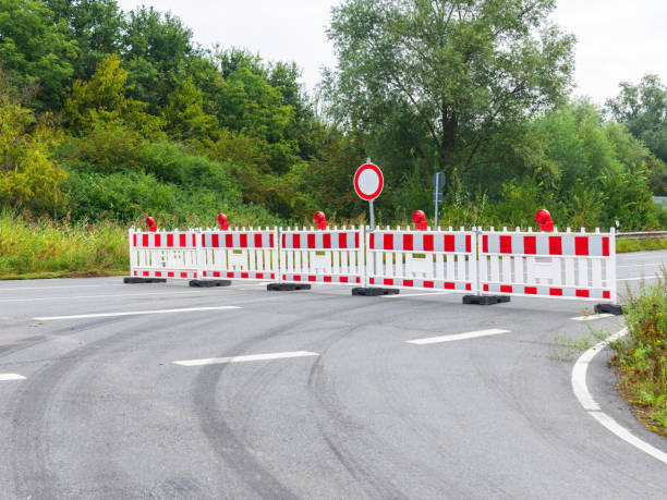 istock Asphalt road is blocked with a red and white plastic barriers due to construction work. Roadwork, no passage prohibited 1802726275
