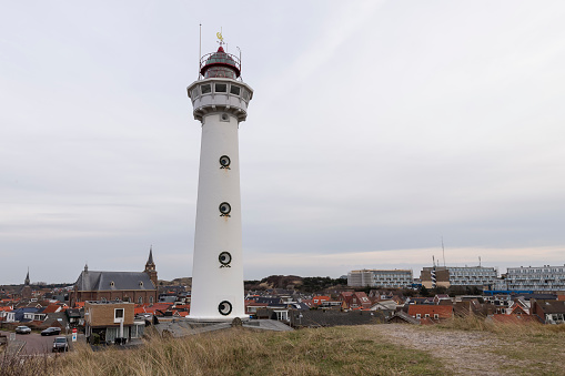 White lighthouse in the dunes in the small Dutch village of Egmond aan Zee in the Netherlands.