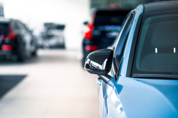New cars at dealer showroom New cars at dealer showroom. Blurred background. Focus is on the right exterior mirror empty dealership interior stock pictures, royalty-free photos & images