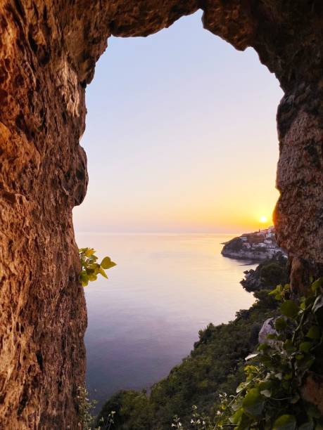 istock View through rock hole on sunset over the sea. 1802728918