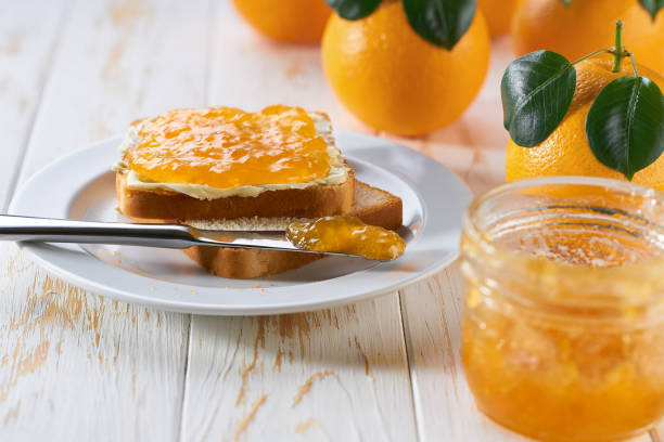 istock Delicious toast with orange jam on the wooden kitchen table. 1802751904