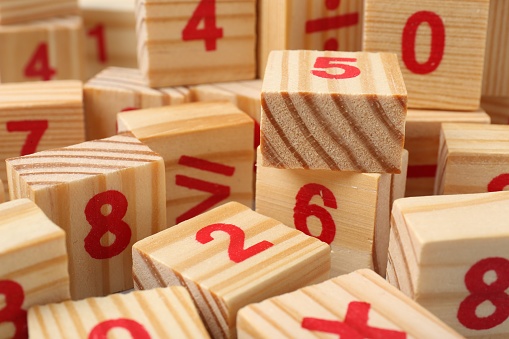 Wooden cubes with numbers and mathematical symbols, closeup