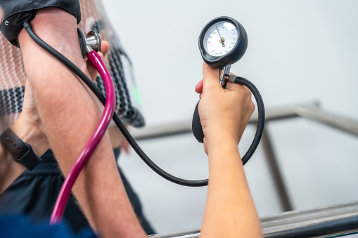 Hand of a cardiologist with a tool to measure the blood pressure