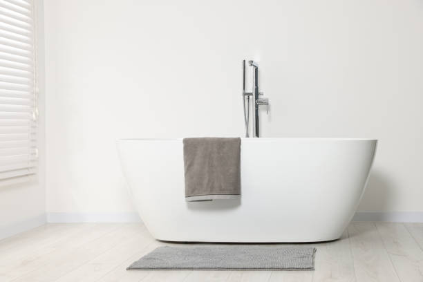 istock Stylish bathroom interior with ceramic tub and terry towel 1802806725
