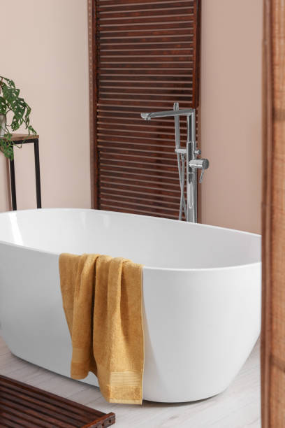 istock Stylish bathroom interior with ceramic tub and terry towel 1802806994