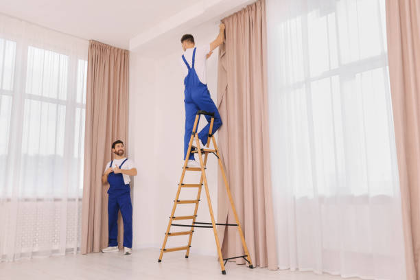 istock Workers in uniform hanging window curtain indoors 1802823678