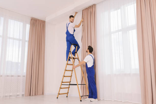 istock Workers in uniform hanging window curtain indoors 1802823679