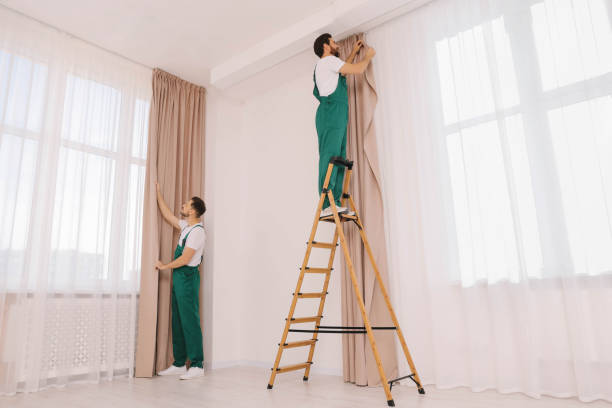 istock Workers in uniform hanging window curtain indoors 1802823686