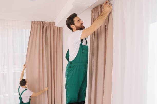 istock Workers in uniform hanging window curtain indoors 1802824214