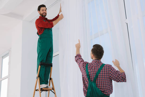 istock Workers in uniform hanging window curtain indoors 1802824749