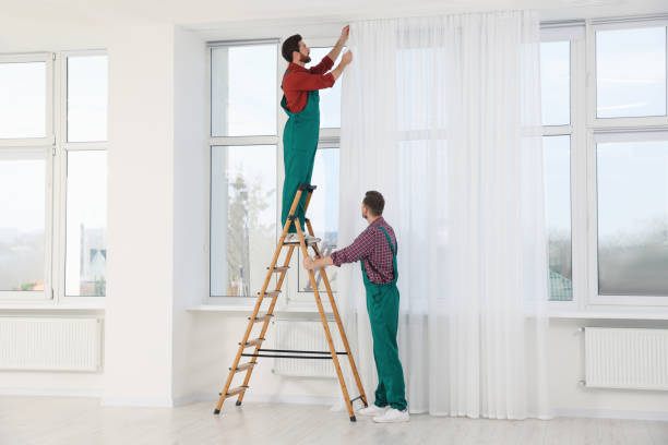 istock Workers in uniform hanging window curtain indoors 1802826857