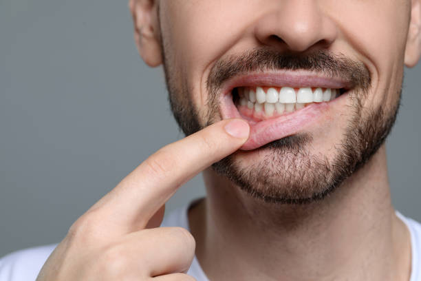 istock Man showing healthy gums on gray background, closeup. Space for text 1802832375