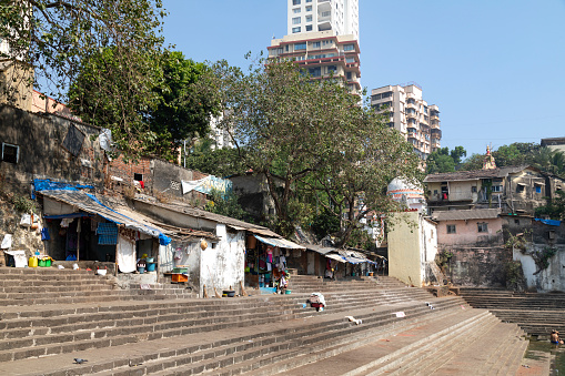 This image features Banganga Tank, a deeply historical and spiritual site nestled in the Walkeshwar Temple Complex in Mumbai. The tank, flanked by stone steps and surrounded by ancient temples and residential buildings, provides a tranquil oasis amid the bustling city. In the photograph, the serene water of the tank contrasts with the vibrant life along its banks, where local residents engage in daily rituals and activities. The image aims to capture the timeless essence of Banganga, highlighting its significance as both a cultural heritage site and a vital element of the local community. It offers a glimpse into the blend of spirituality, history, and everyday life that defines this unique corner of Mumbai.