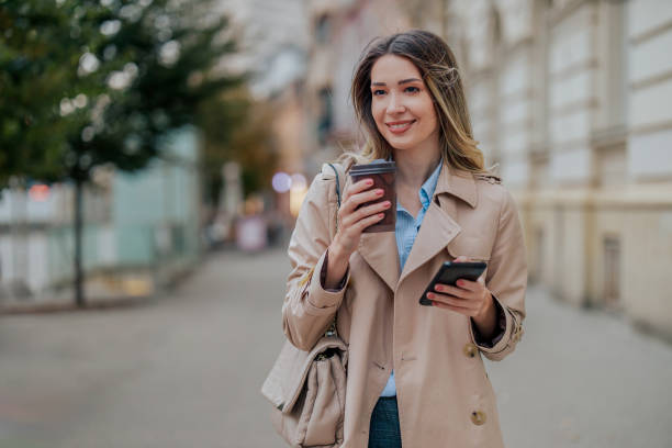 istock Portrait of a woman using a smartphone while drinking coffee takeaway outside 1802842286