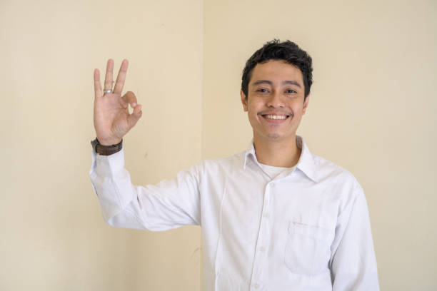 istock Young Indonesian curly man wear white clothes with ok pose. 1802848786
