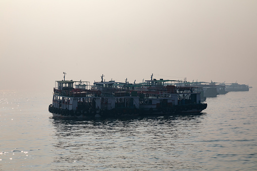This image presents a picturesque scene of boats anchored near the Gateway of India in Mumbai. The historic arch-monument, built during the British Raj, forms an imposing backdrop, symbolizing the city's colonial past and its transition into a modern metropolis. In the foreground, an array of boats, ranging from small fishing vessels to larger tourist ferries, bob gently on the Arabian Sea's waters. The photograph captures the essence of Mumbai's coastal identity, showcasing the vibrant maritime activity that is a staple of life in this bustling port city. The image aims to juxtapose the enduring legacy of the Gateway of India with the daily hustle of the city's vibrant seafaring culture.