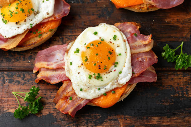 istock Bagel sandwich with bacon, egg and cheese on wooden table. 1802875280