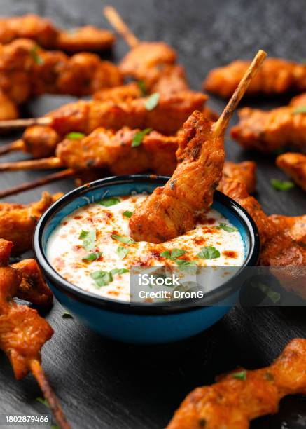 Grilled Chicken Fillet On Skewers With White Sauce On Rustic Stone Board Stock Photo - Download Image Now