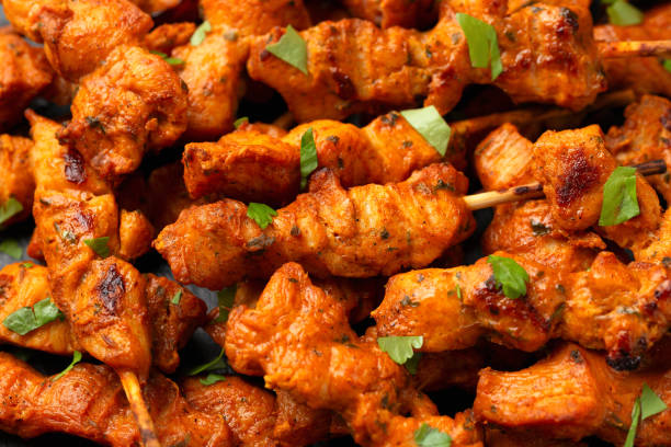 istock Grilled chicken fillet on skewers with white sauce on rustic stone board 1802879469