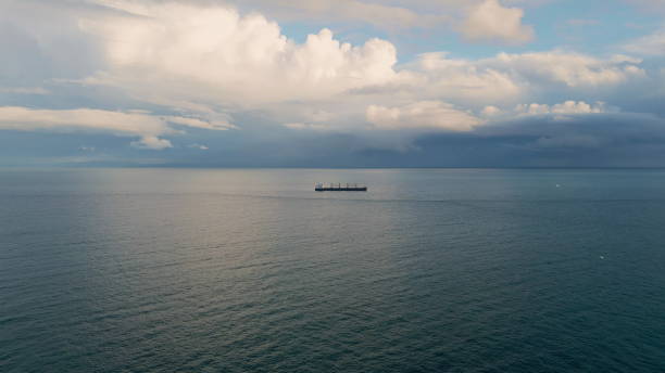 istock Bulk carrier ship sailing at cloudy day. Aerial view vessel floating dark ocean 1802907746