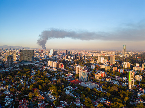 Warehouse fire in downtown Mexico City, visible across the city, before sunset.