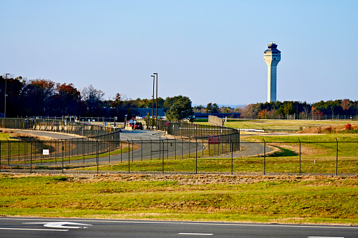 Chantilly, Virginia, USA - November 12, 2023: The Washington Dulles International Airport’s Air Traffic Control Tower stands out against a clear blue sky on a late Fall afternoon.