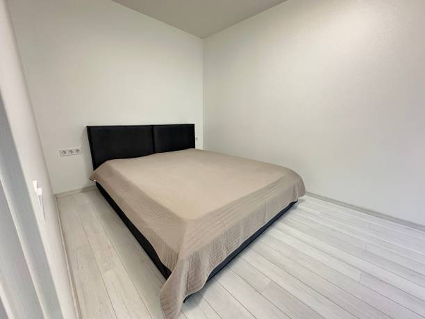 istock bed in a room with white walls 1802963702