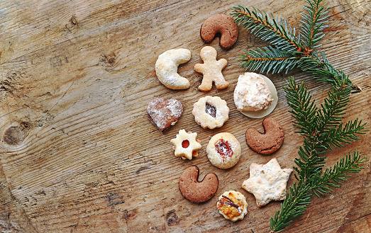 Christmas cookies and fir branches on a wooden background