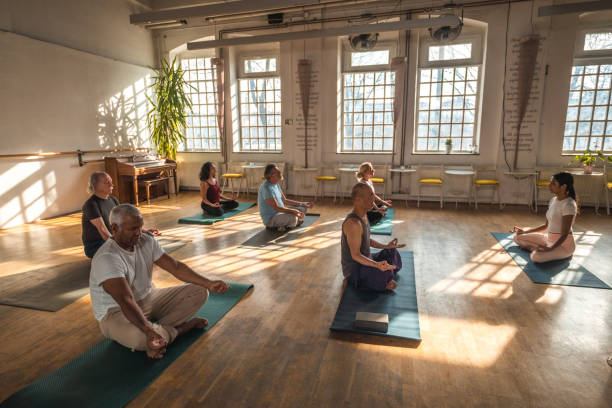 goldene jahre: aktive senioren profitieren von den vorteilen von yoga - 60 65 years stock-fotos und bilder