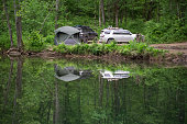 Overlanding campsite by calm stream in the woods