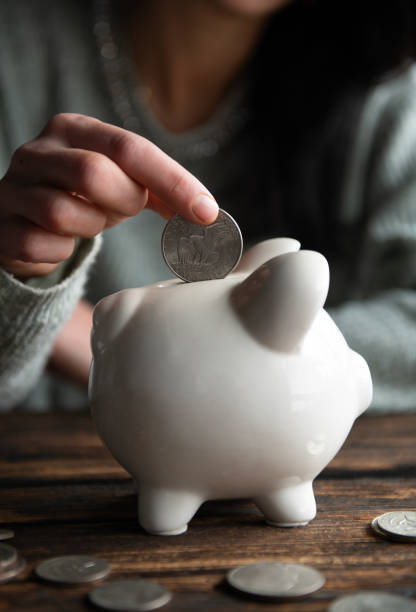 istock Hand holding coin with pig piggy bank 1803041849
