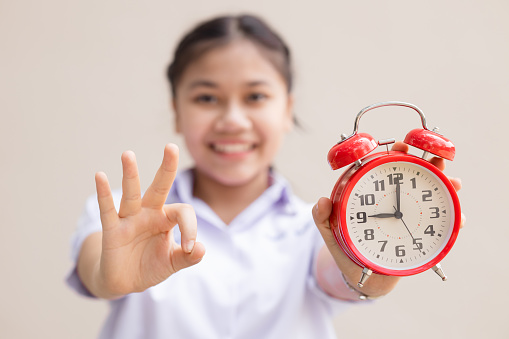 Teen girl student with alarm time clock for ready education times back to school concept happy smile.