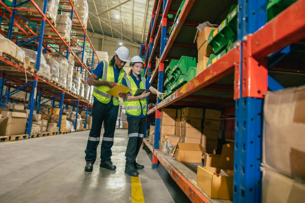 istock warehouse worker teamwork working help assist young new worker checking products stock for shipping order. 1803053631