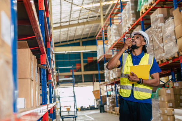 istock warehouse african black male worker. inventory clerk staff working radio control loading check remaining products in stock. 1803053636