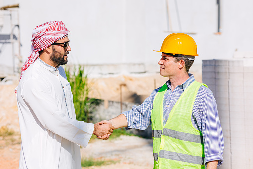 Arab business man handshake with american engineer builder construction new building project together