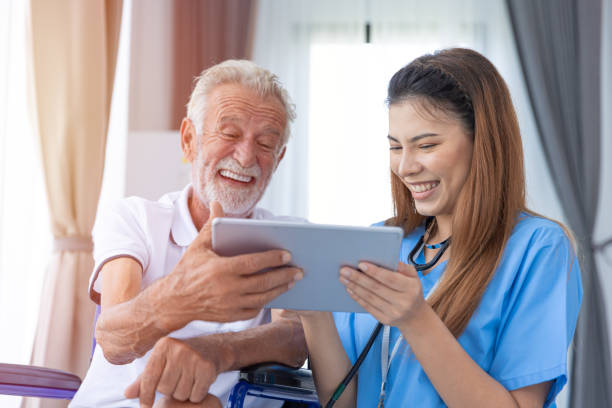 szczęśliwy, zdrowy starszy mężczyzna starzec lubi oglądać czat wideo na ekranie tabletu w domu opieki z lekarzem - family domestic life senior adult computer zdjęcia i obrazy z banku zdjęć