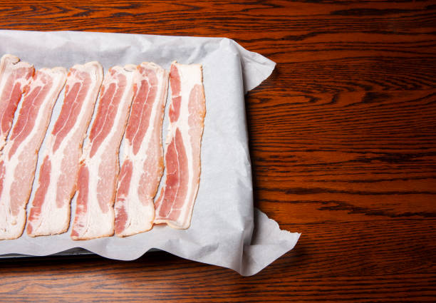 istock Raw bacon on a sheet of parchment paper. 1803068919