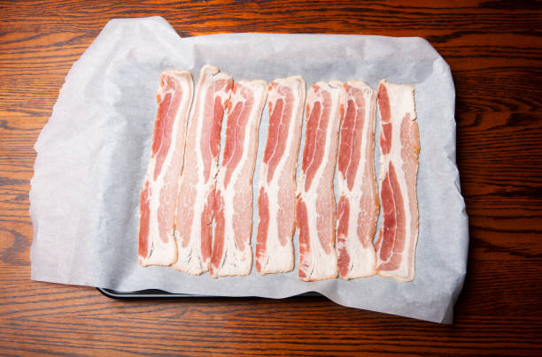 istock Raw bacon on a sheet of parchment paper. 1803068923