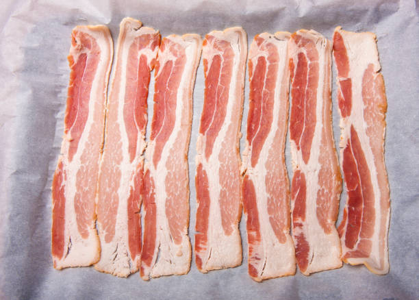 istock Raw bacon on a sheet of parchment paper. 1803068927