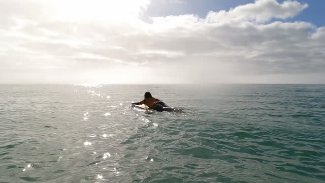 First person perspective of young woman surfing