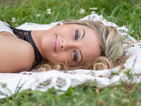 Beautiful young girl relaxing lying on the grass