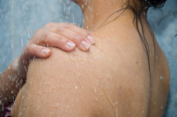 istock close up of woman's shoulder wet in shower 1803097155