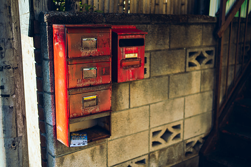 Mailbox on blue sky background. Empty retro mail box red color on white post with open door and raised flag, space. Traditional correspondence concept. 3d illustration