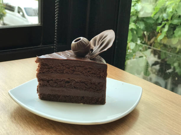 Chocolate cake on wooden table in coffee shop. Selective focus.