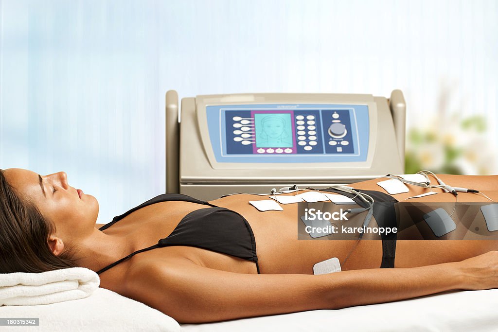 Woman having electrical lymphatic drainage. Young woman having electrical lymphatic drainage in spa. Electrode Stock Photo