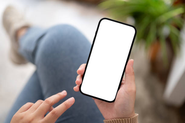 istock A woman using her smartphone while relaxing indoors, A white-screen smartphone mockup 1803160907