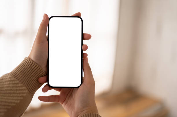 istock A woman hands holding a white-screen smartphone mockup over a blurred background. close-up image. 1803162020