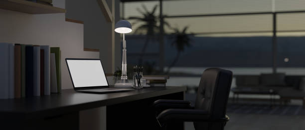 istock Modern dark home office space with blank screen mock up tablet on dark wooden table, large window with sea view. 1803245041