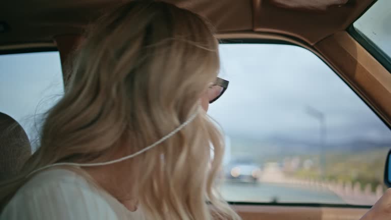 Gorgeous woman driving car in sunglasses close up. Girl riding on retro auto