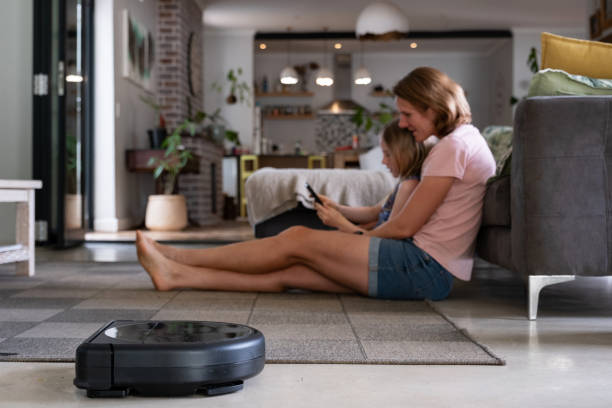 istock Robotic Vacuum Cleaner Cleaning While Mother and daughter play 1803256621